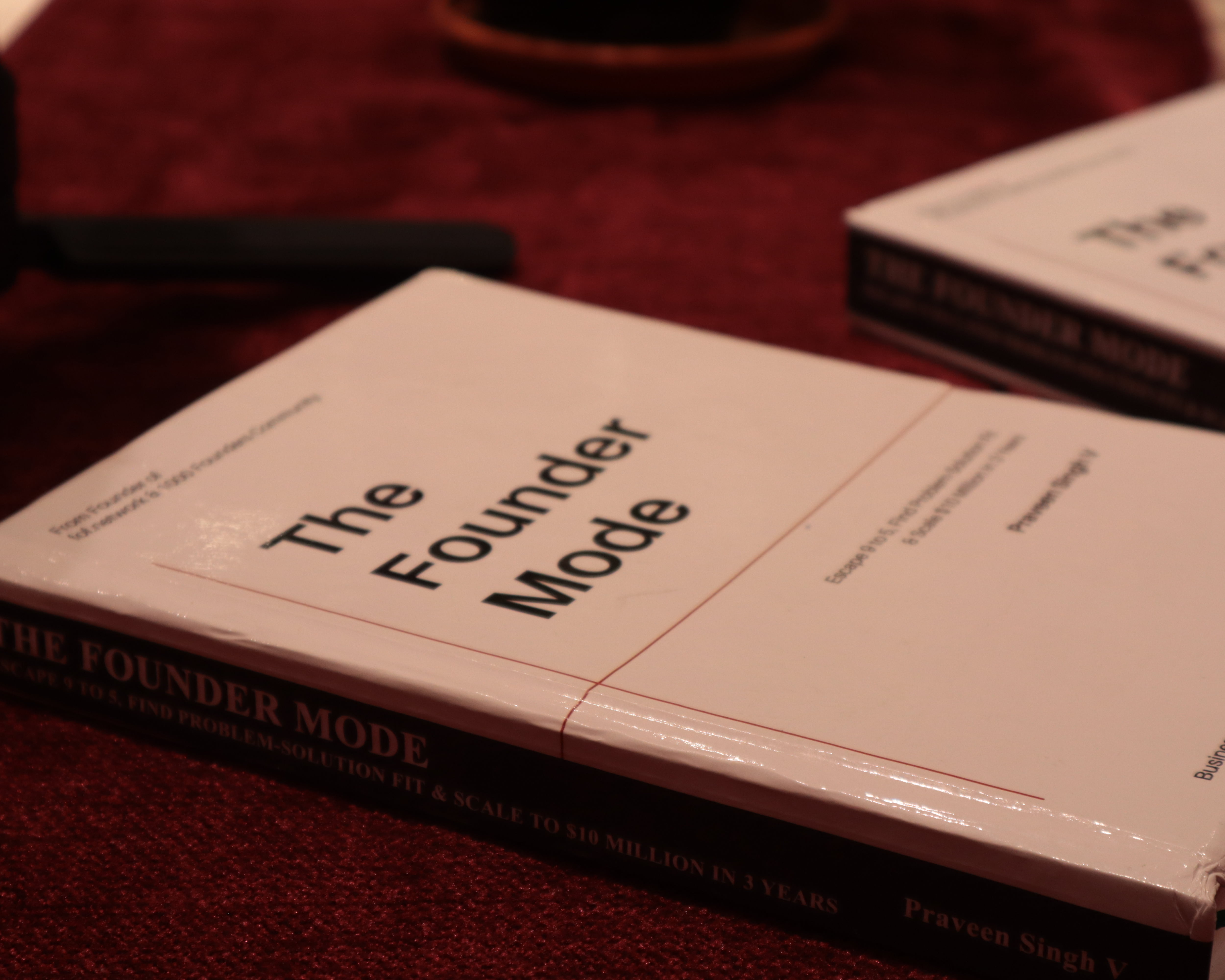 The Founder Mode — book by Praveen Singh V, on burgundy velvet